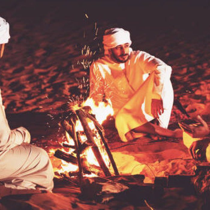 Arabs seated around campfire and enjoying casual conversation