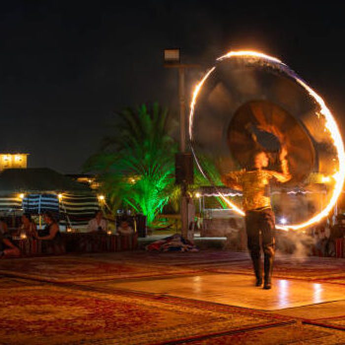Dubai, United Arab Emirates - September 17, 2024: Man performing for tourist at the desert camp after dune bashing